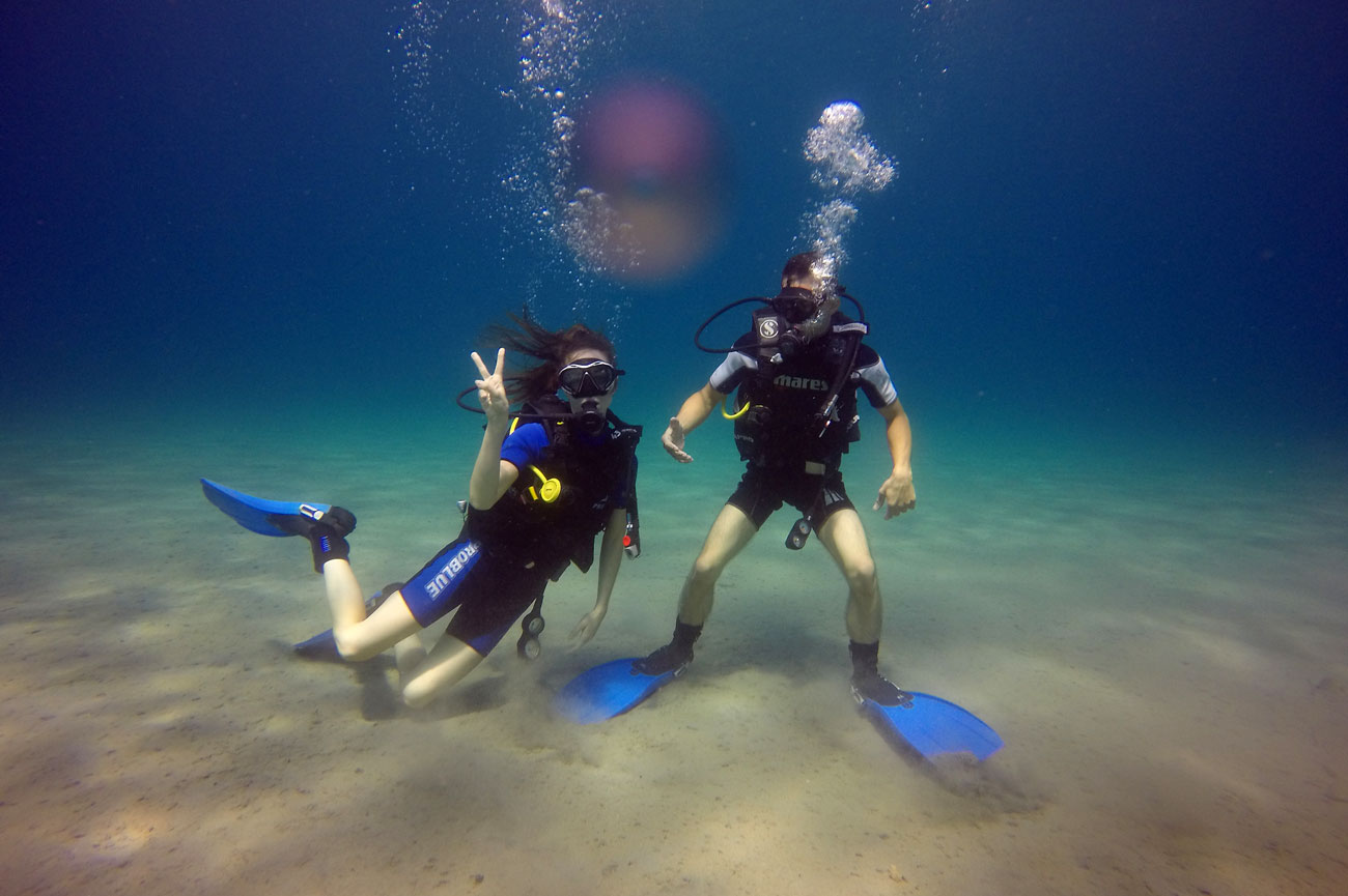 Discover scuba diving students gining the V signal to the camera